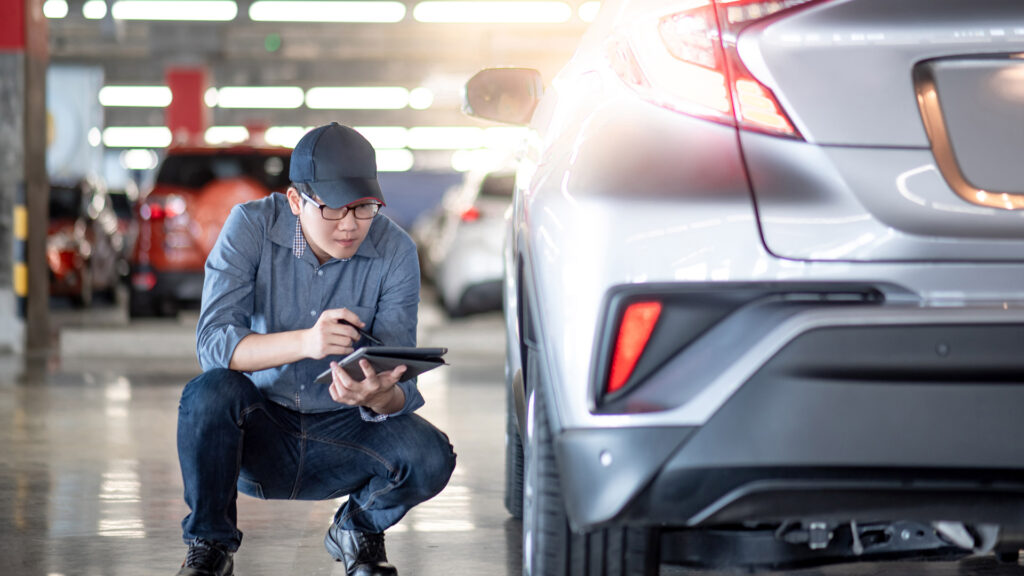 mechanic checking fixes on car with tablet in vehicle repair shop